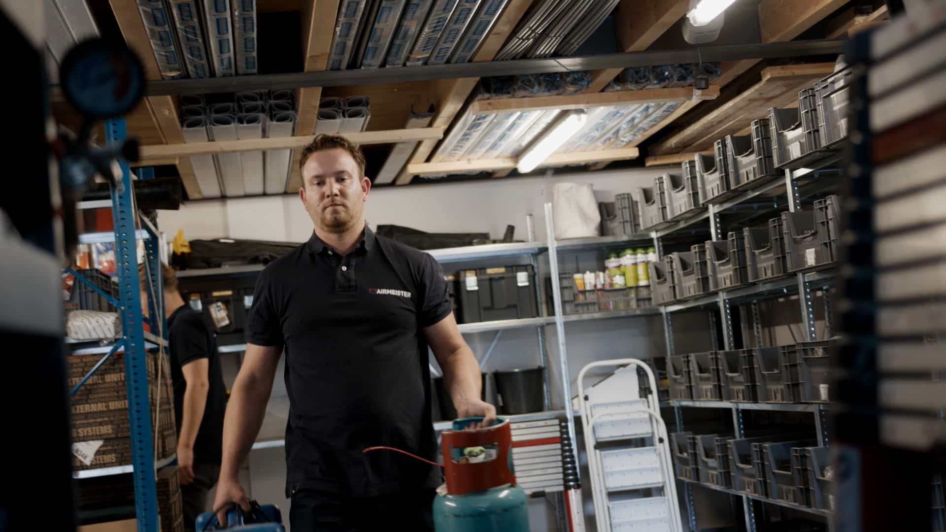 Medewerker verplaatst gasfles in magazijn.